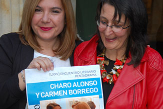 Carmen y Charo posan junto al cartel